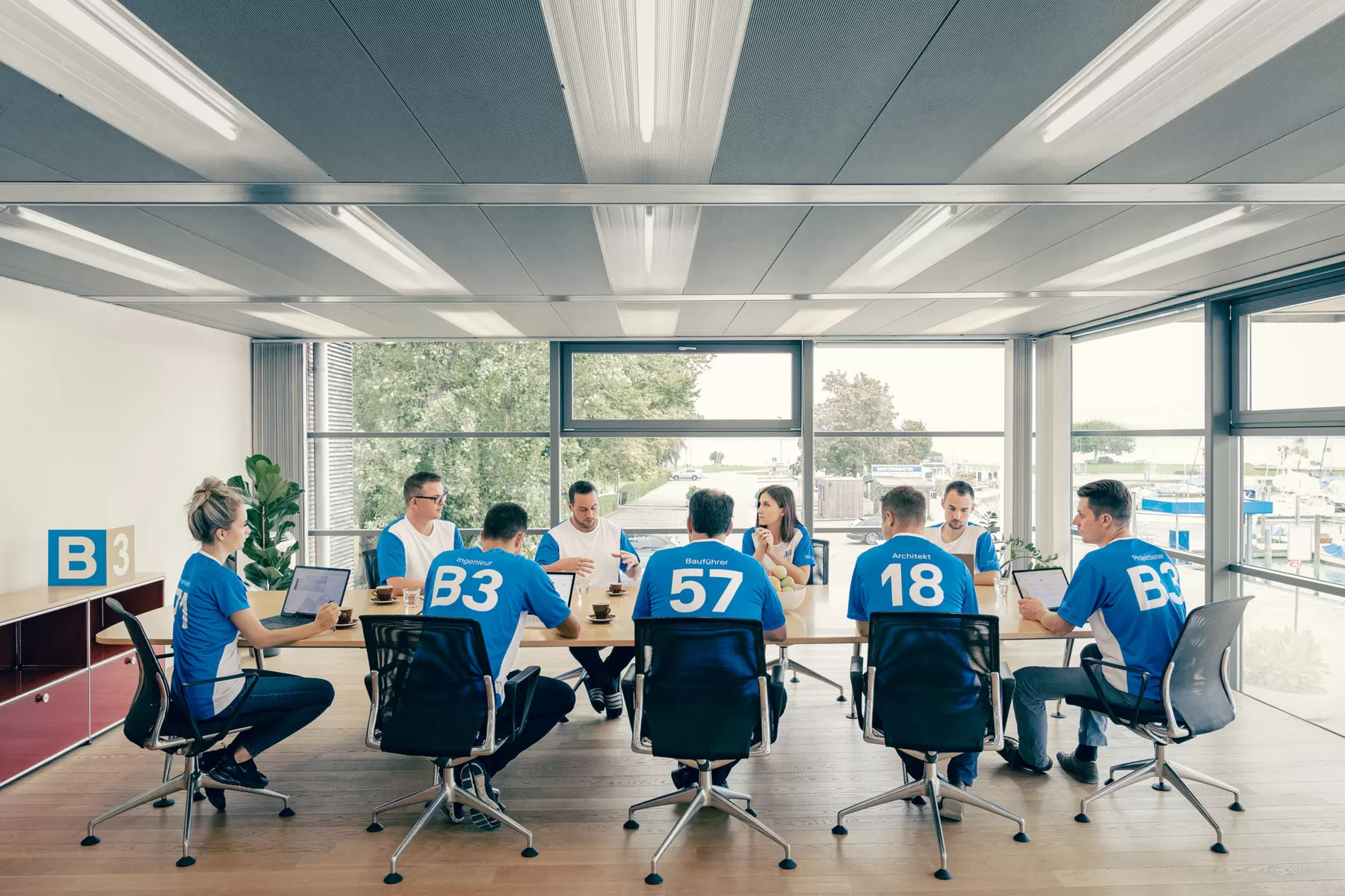 Viele Menschen sitzen in einem Raum und tragen das gleiche T-Shirt