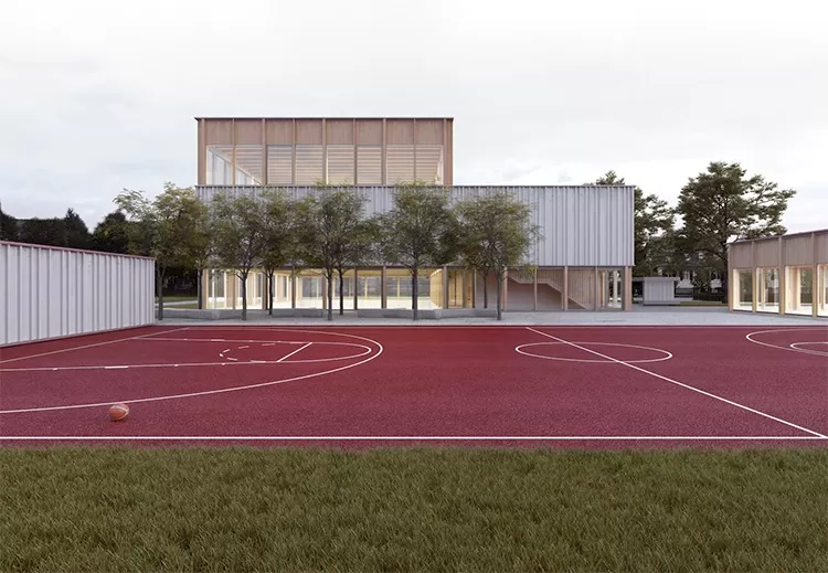 Roter Sportplatz mit Baseketball. Im Hintergrund hat es Geb&auml;ude und B&auml;ume